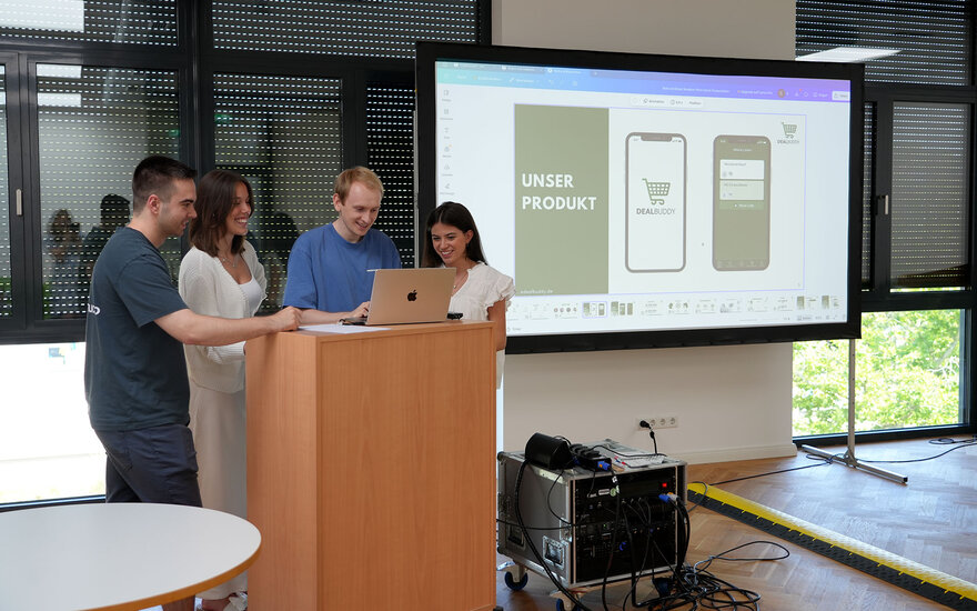 Christoph, Clarissa, Emilia und Marc besprechen sich am Pult 