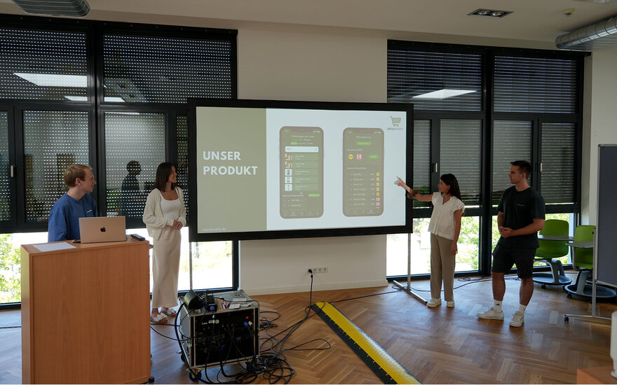 Studierende stellen ihre Idee mithilfe eines Whiteboards vor
