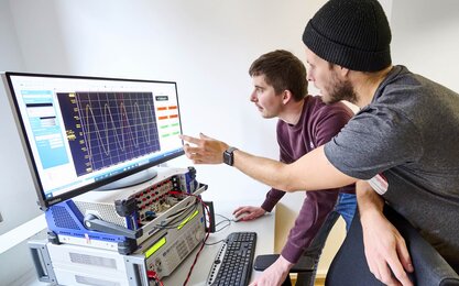 Zwei Doktoranden im Labor für Elektrische Maschinen, Leistungselektronik und Antriebe.