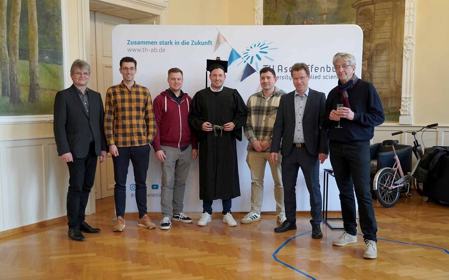 Gruppenfoto von Timm Sauer mit Doktorhut und 6 Personen des Promotionsteams