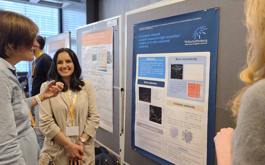 Promovierende stehen zur Vorstellung ihrer Poster neben Pinnwänden