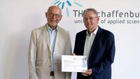 VDE-Geschäftsführer und VDE-Vertrauensdozent mit Urkunde vor TH-Logowand