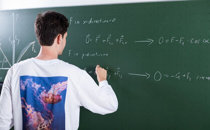 Studierender schreibt an die Tafel während einem Tutorium