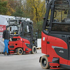 Zwei Gabelstapler fahren autonom auf dem Firmengelände umher, wobei vor einem Stapler eine Dummy-Person läuft
