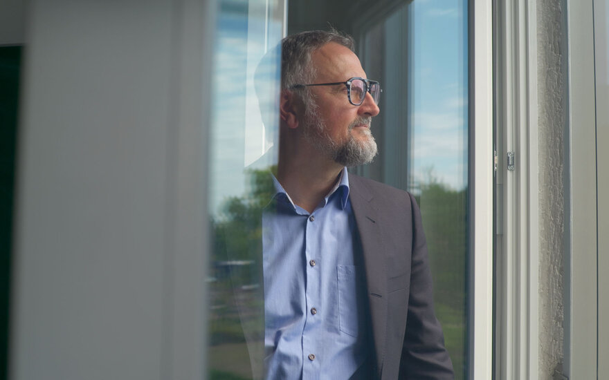 Profilaufnahme von Professor Lars Schöne, der aus einem Fenster herausschaut