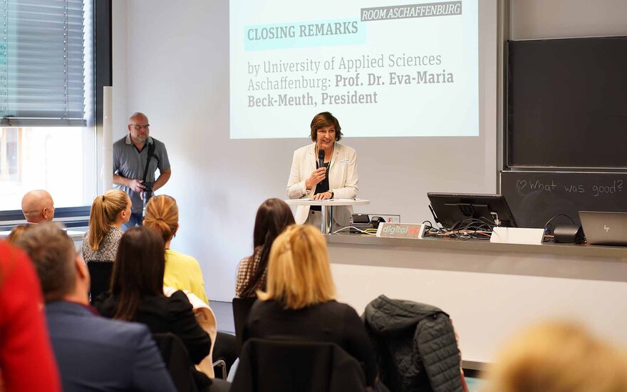 Frau spricht vor sitzendem Publikum