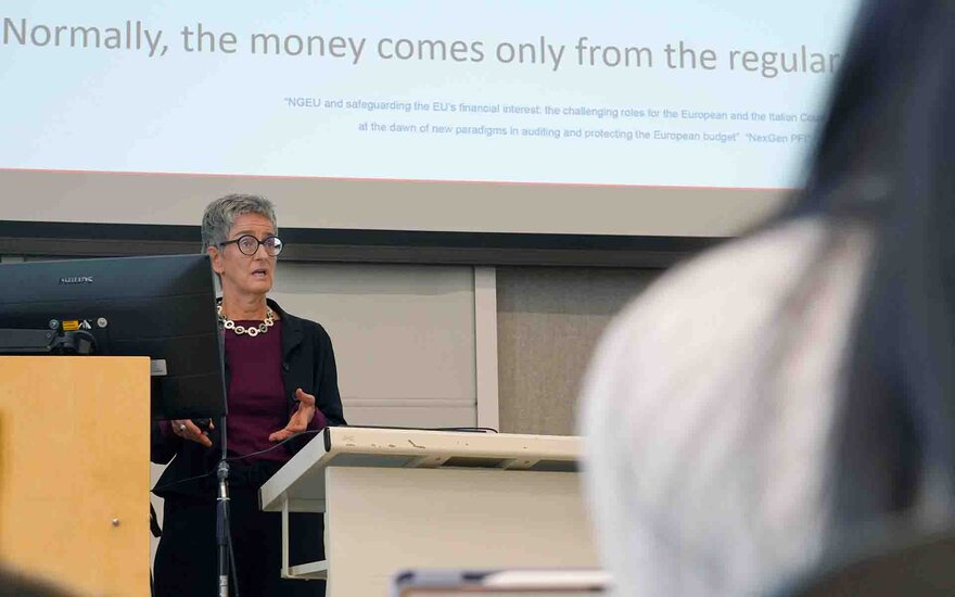Professorin Balleis am Rednerpult vor Leinwand mit Präsentation