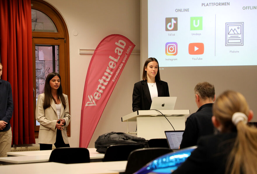 Studierende halten am Pult eine Präsentation über ihre Start-Up Idee 