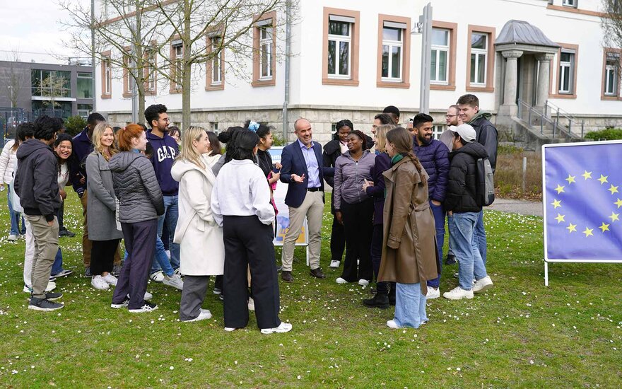 Der Gastreferent auf der Campuswiese mit den Studierenden im Gespräch