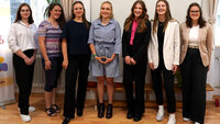 Sieben junge Frauen in einer Reihe, lächeln in die Kamera, rechts und links von ihnen Zonta-Roll-Ups
