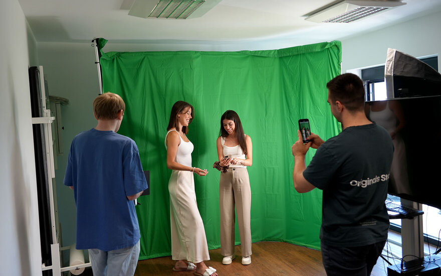 Christoph, Clarissa, Emilia und Marc bereiten vor einem Greenscreen ein Fotoshooting vor