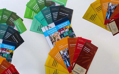 Studiengangsflyer der TH Aschaffenburg, Flyer Zusammen stark in die Zukunft und Flyer Studieren an der TH Aschaffenburg aufgefächert auf einem Tisch