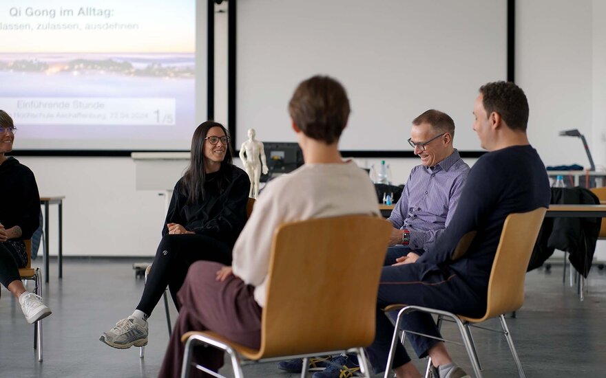 Mehrere Personen sitzen am Gesundheitstag in einem Stuhlkreis.