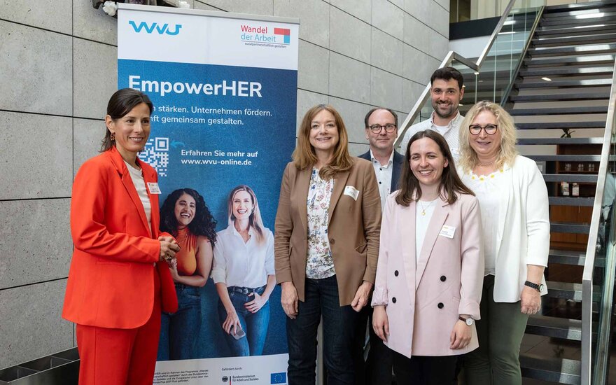 Gruppenfoto der Beteiligten mit zwei Männern und vier Frauen vor EmpowerHer-Rollup