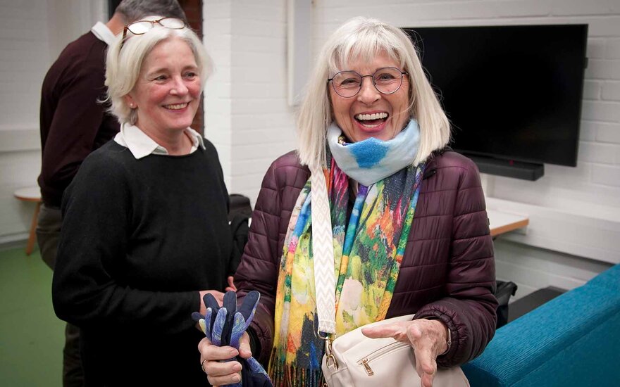 Zwei grauhaarige Frauen unterhalten sich lachend