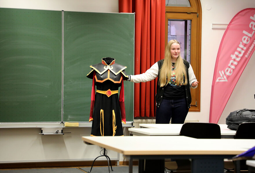 Eine Studentin zeigt ein Kostüm an einer Büstenpuppe