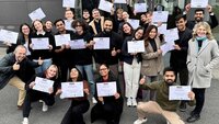 Gruppenfoto der Mercuri-Studierenden auf dem Campus mit Zertifikaten in der Hand