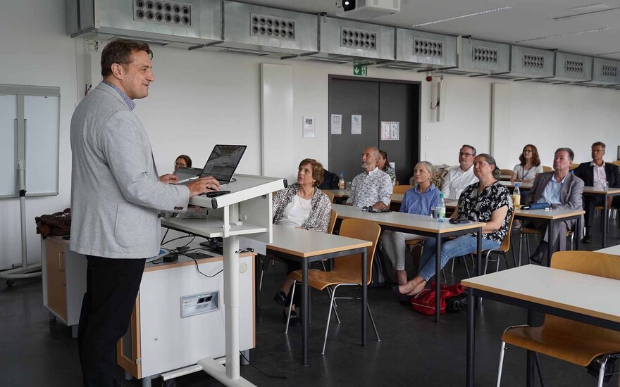 Der Baubeauftragte steht am Rednerpult mit Blick auf die sitzenden Stadtratsmitglieder