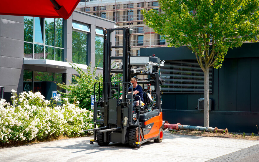 Luca Spielmann fährt einen Gabelstapler im Freien.