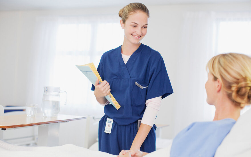 Eine Hebamme kümmert sich um eine Patientin.