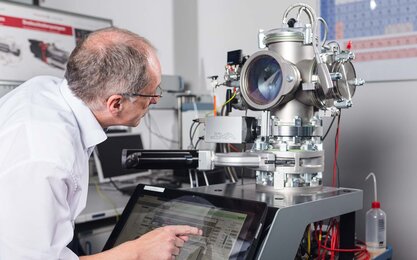Ein Professor während einer Messung an der Sputteranlage im Labor für Beschichtungstechnik.