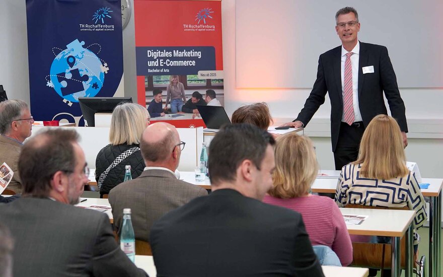 Professor Schäfer spricht zu den sitzenden Gästen der ECOM-Auftaktveranstaltung