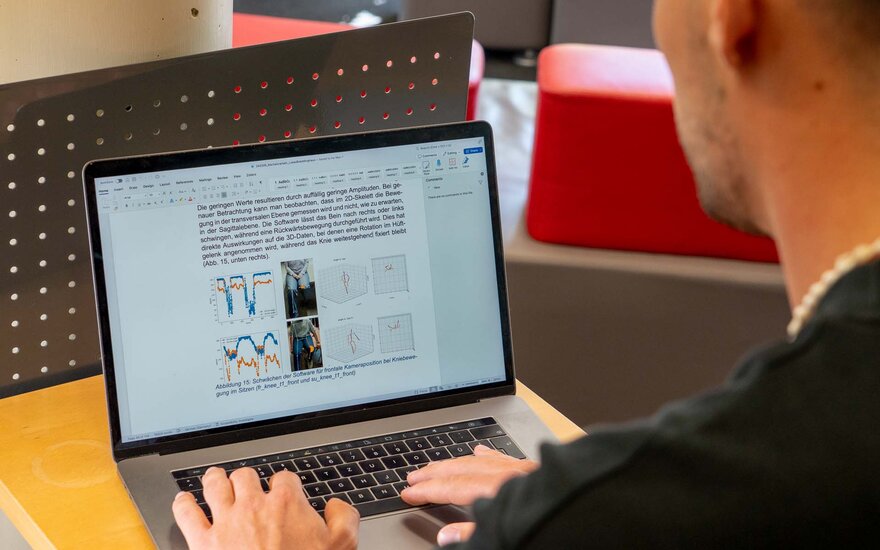 Ein Mann tippt auf seinem Laptop