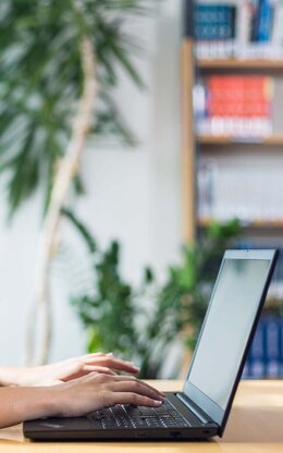 Studentin mit Laptop in der Bibliothek