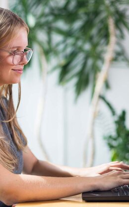 Studentin mit Laptop in der Bibliothek
