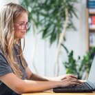 Studentin mit Laptop in der Bibliothek