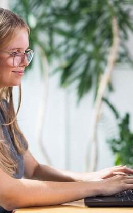 Studentin mit Laptop in der Bibliothek