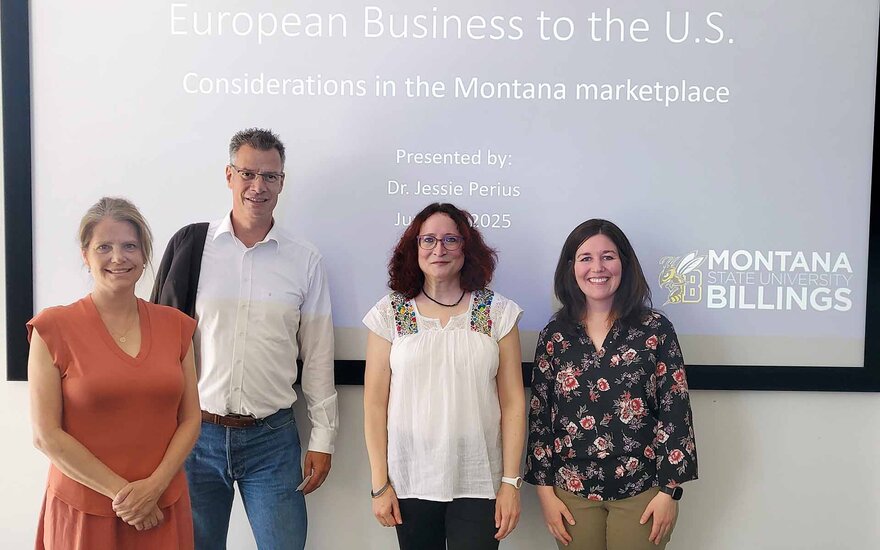 die beiden Gastprofessorinnen, Professorin Link und Vizepräsident Schäfer stehen nebeneinander vor der Leinwand mit dem Vortragstitel