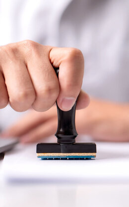 Signatur eines Dokuments durch einen Stempel.