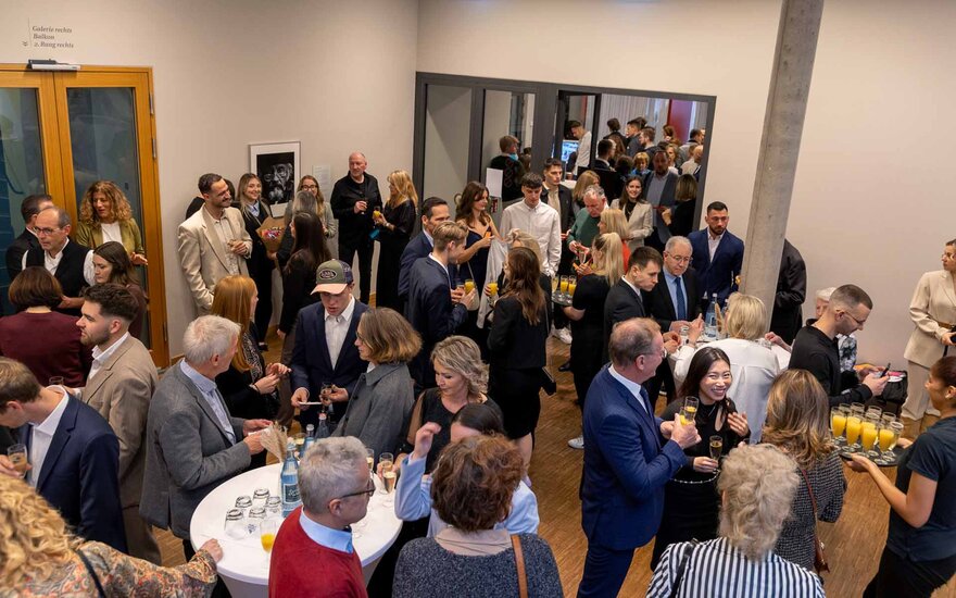 Große Menge an Menschen im Theaterfoyer beim Sektempfang