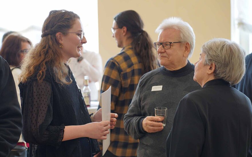 Stipendiatin im Gespräch mit Ehepaar, dass sie fördert