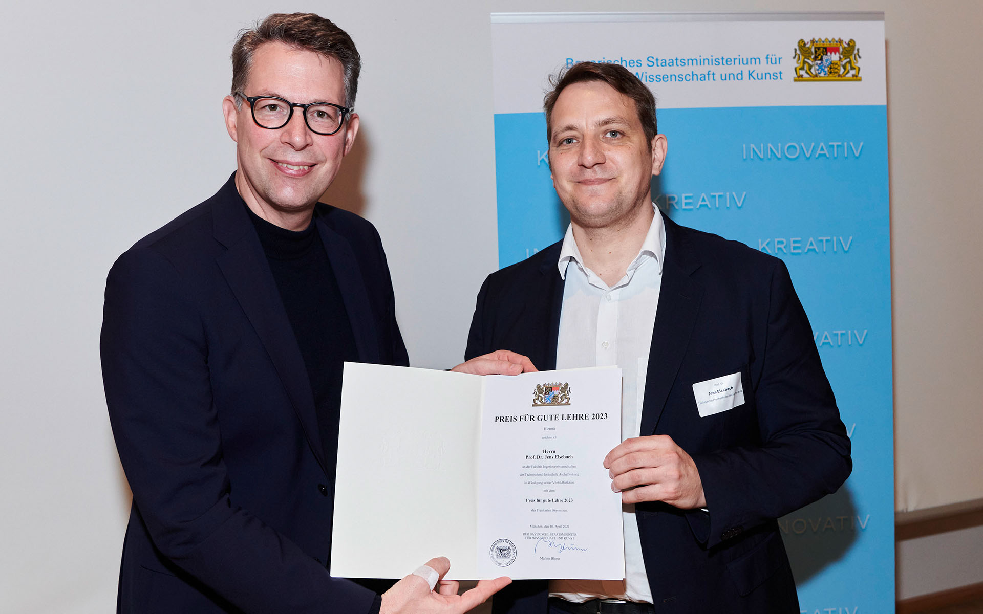 Staatsminister Markus Blume überreicht Professor Elsebach die Urkunde