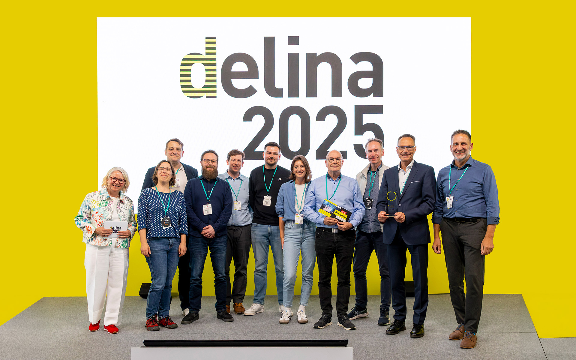 Team des Projekts AdLer bei der Verleihung des delina Award auf der Bühne mit Trophäe