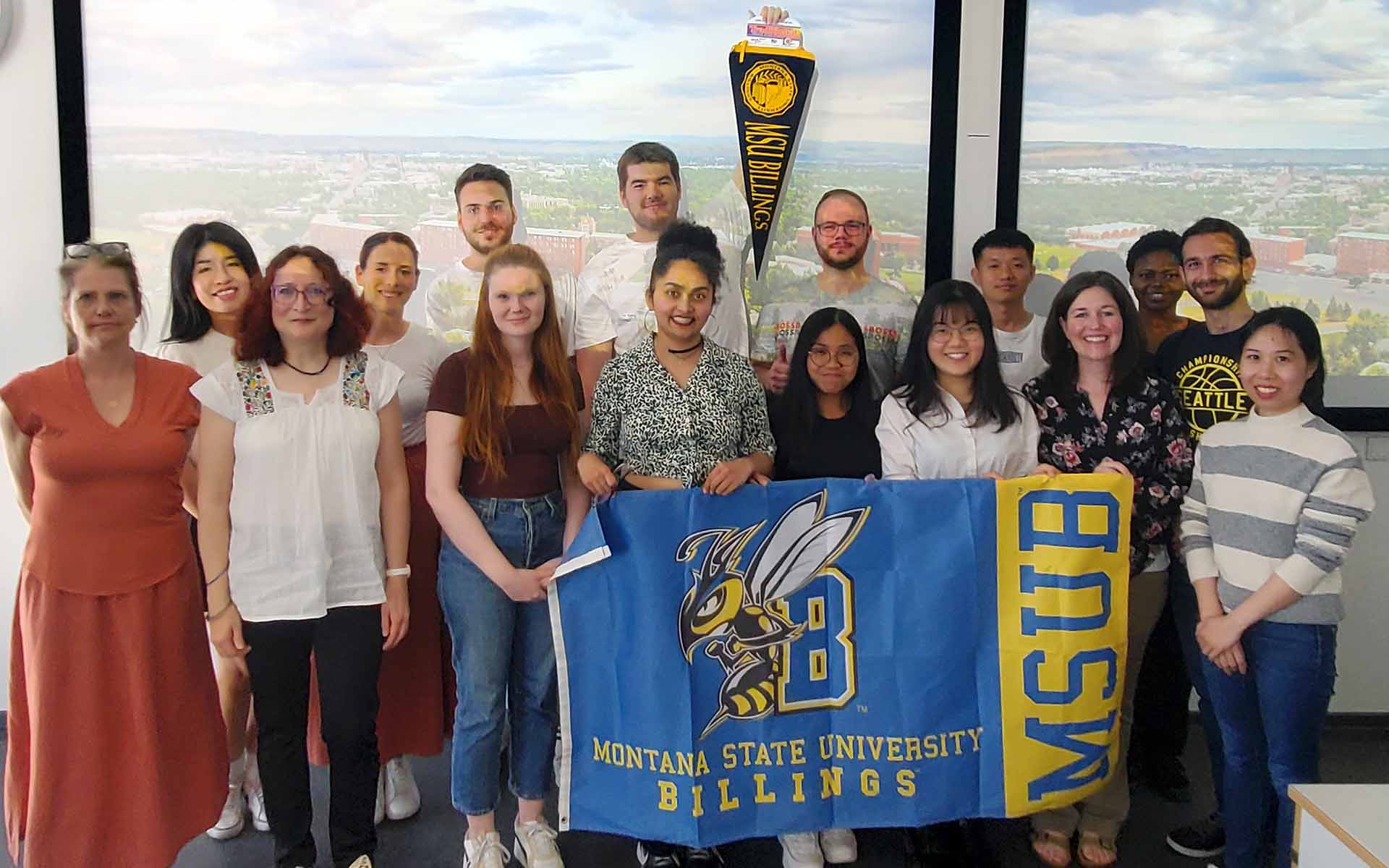 Gruppenfoto mit Gastprofessorinnen, Studierenden und blau-gelber Flagge der Montana State University 