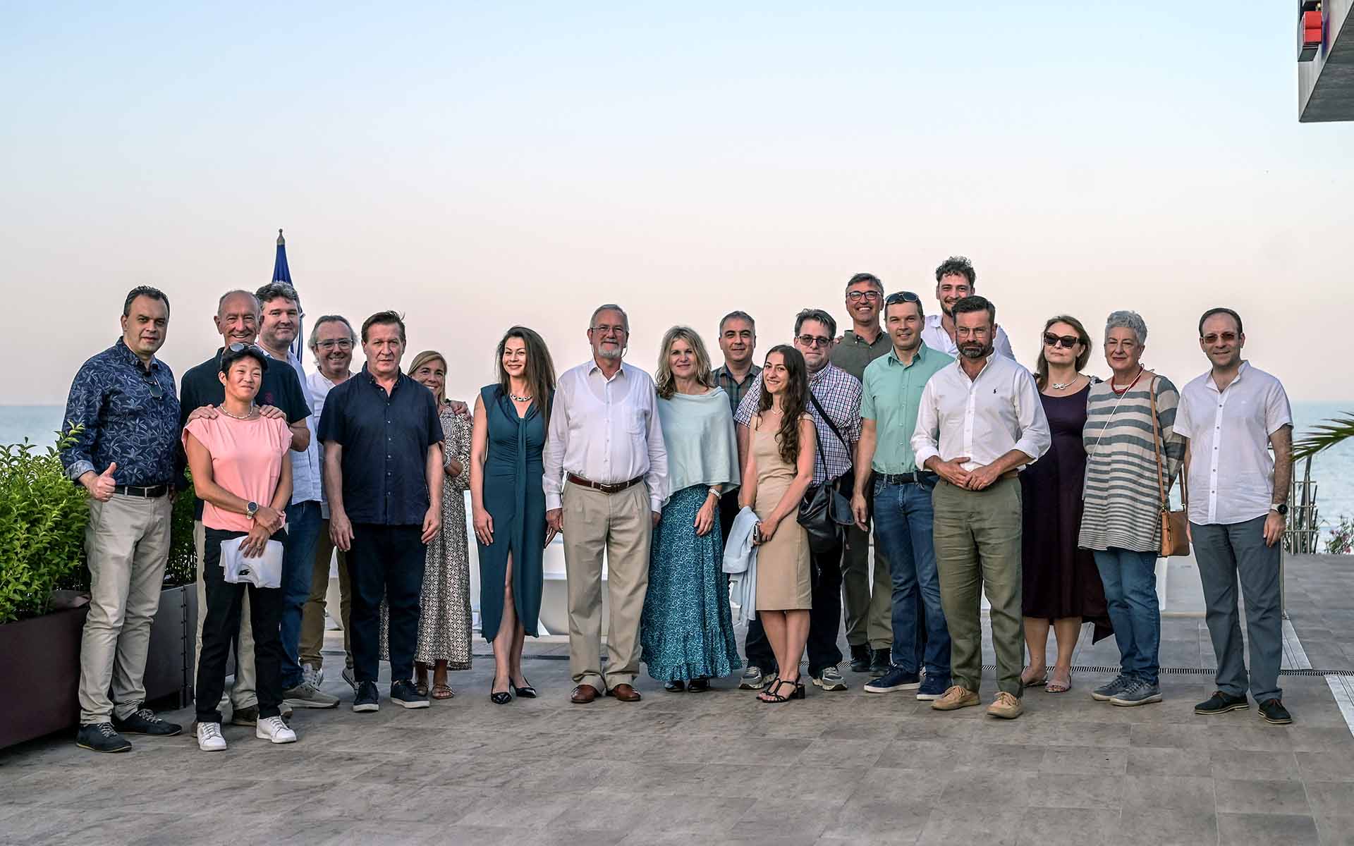 Gruppenfoto mit zwanzig nebeneinanderstehenden Personen im Freien 