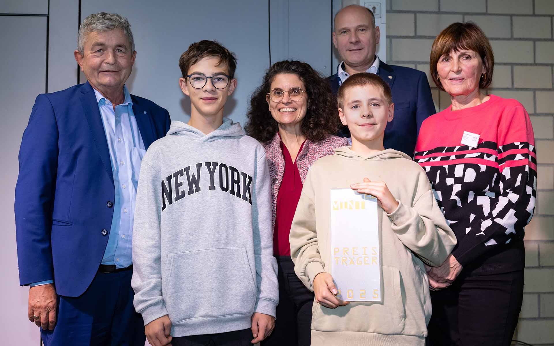 Gruppenbild mit zwei Jungen mit Urkunde, zwei Männer und zwei Frauen