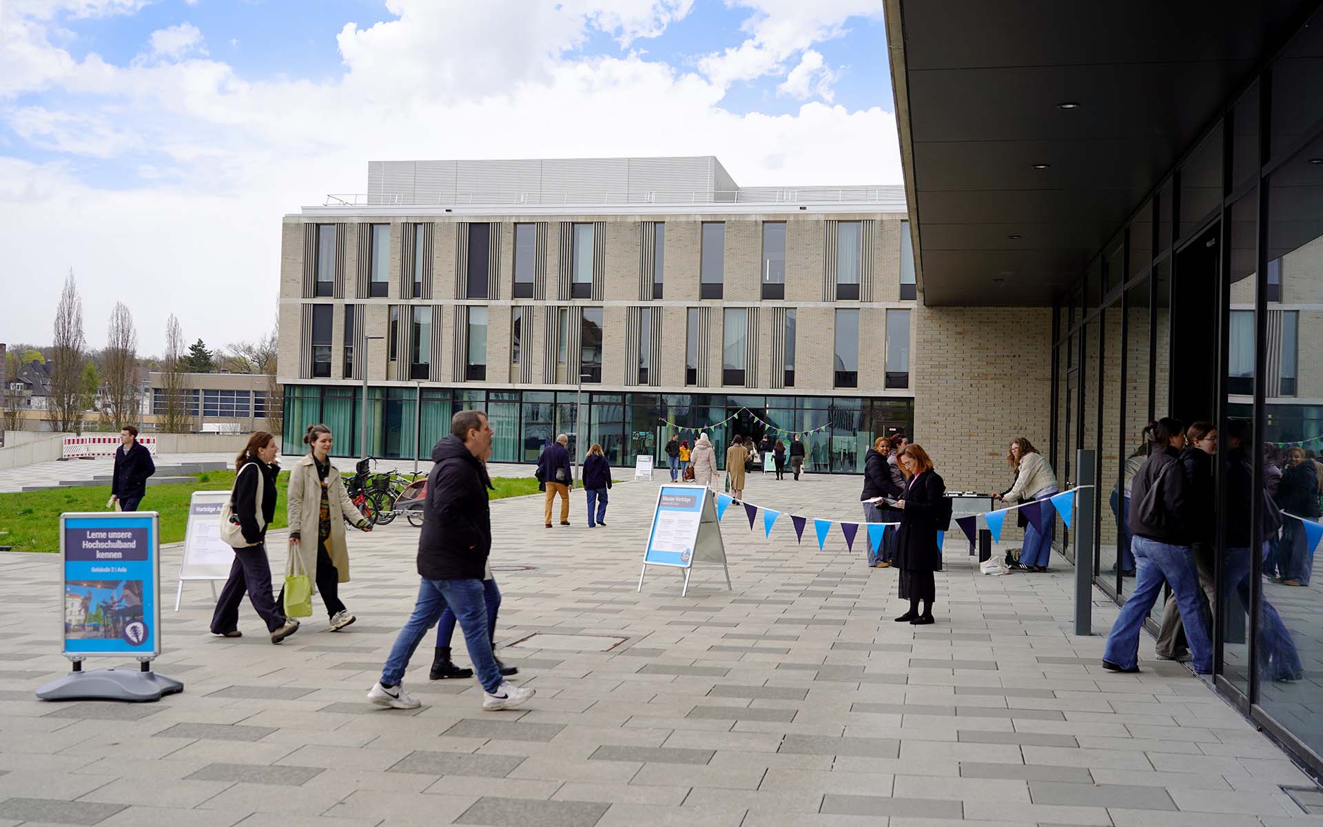 Personen laufen auf die Eingänge der neuen Gebäude zu 