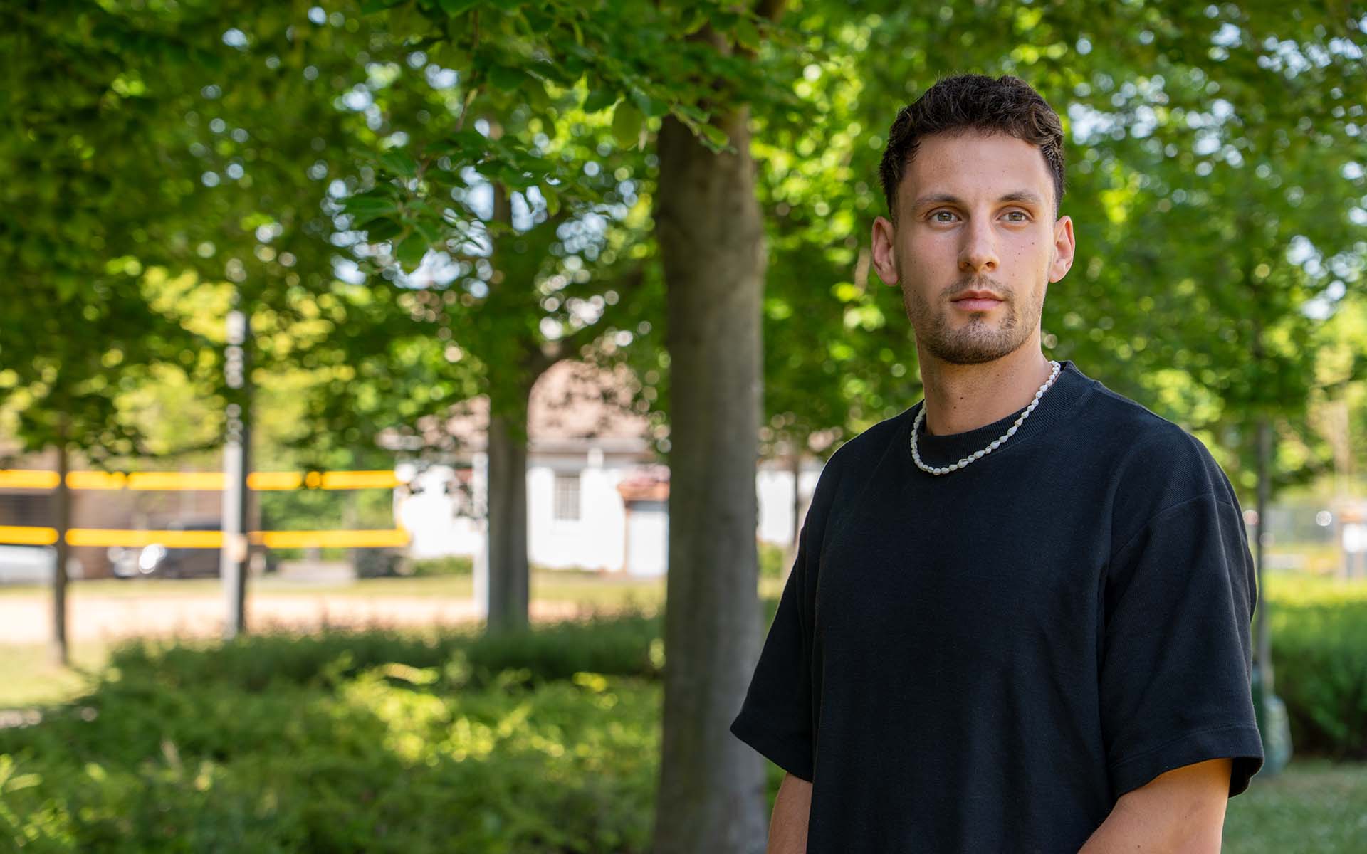 Lukas Boeddinghaus vor einigen Bäumen auf der Campuswiese